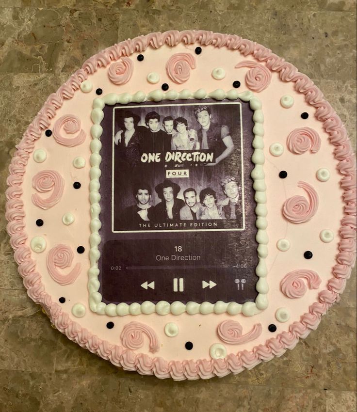 a cake that is decorated with pink icing and an old movie poster on it