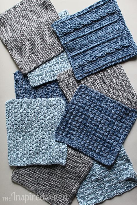 several knitted squares are laid out on the table top, all in different shades of blue and grey