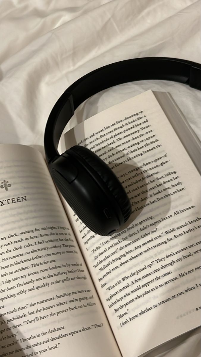 an open book with headphones on top of it