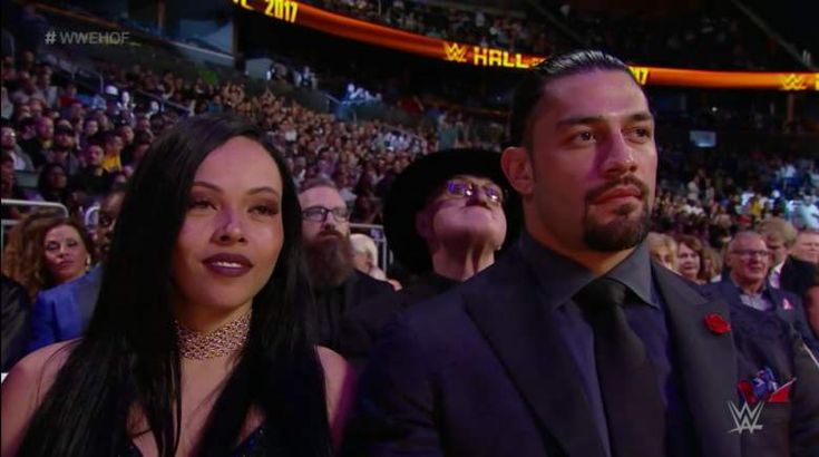 a man and woman sitting next to each other in front of an audience at a sporting event