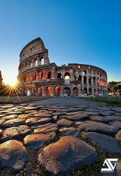 the roman colossion in rome at sunset, with sun shining down on it