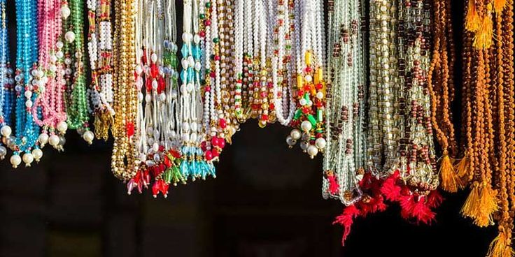 a bunch of beads hanging from the side of a building with tassels attached to it