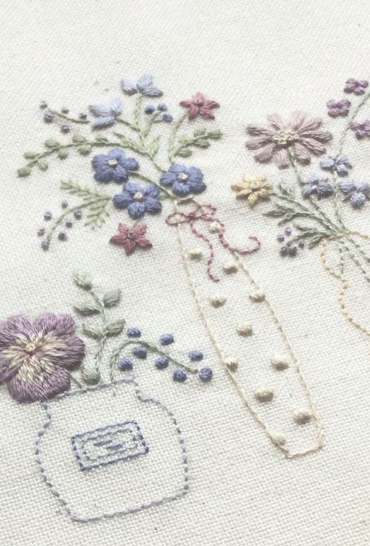 some flowers and beads are on a white table cloth with stitching in the middle