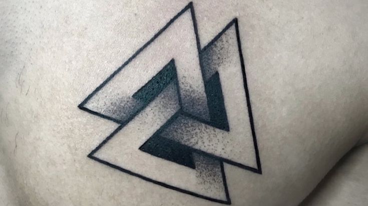 a black and white photo of a triangle tattoo