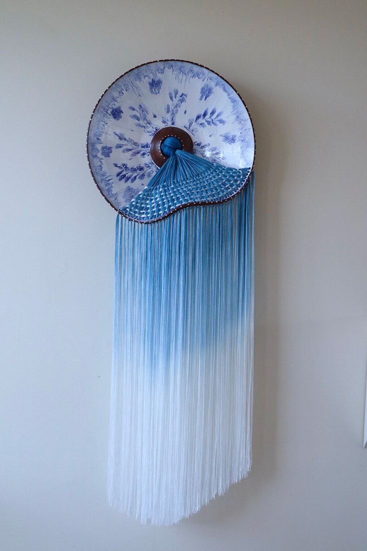 a blue and white fan hanging on the wall