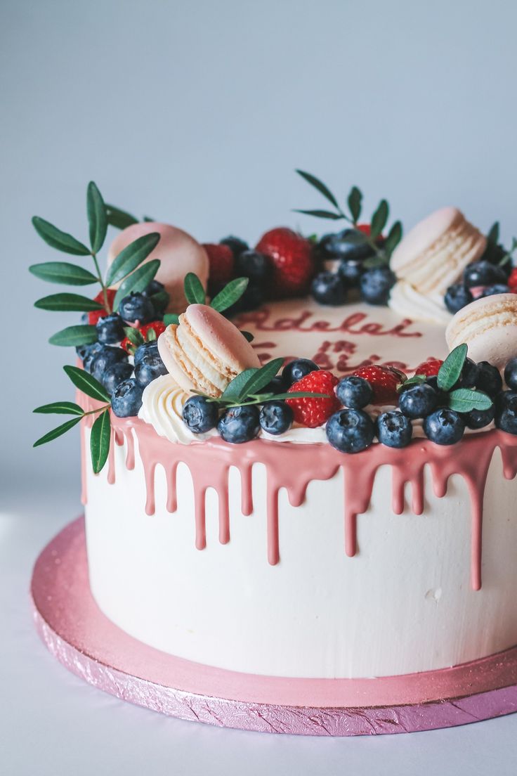 a cake decorated with berries, blueberries and macaroons