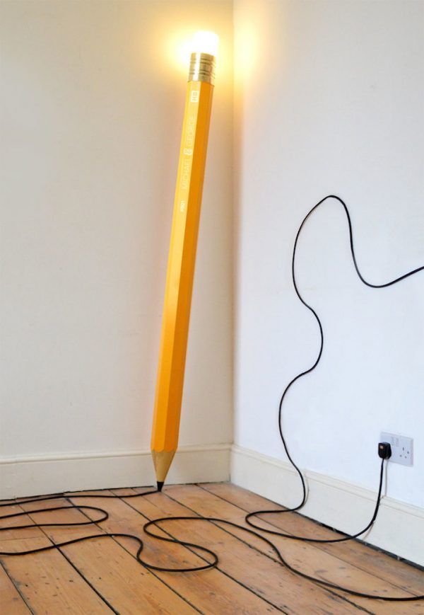 a light that is sitting on the floor next to a pencil with wires coming out of it