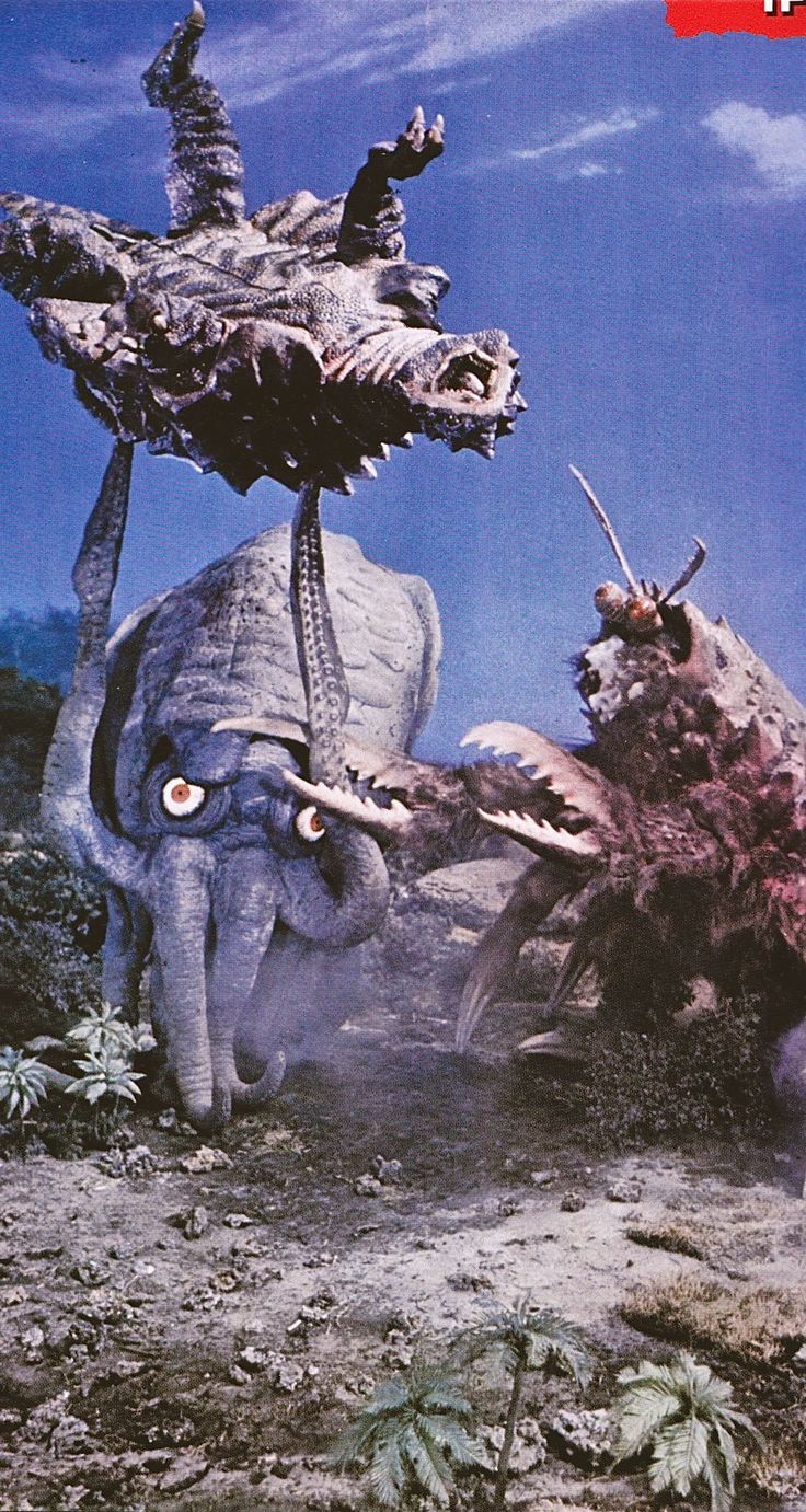 an elephant attacking another animal with its trunk and tusks on the ground in front of a blue sky