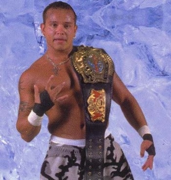 a man holding a wrestling belt in front of a blue wall with snow on it