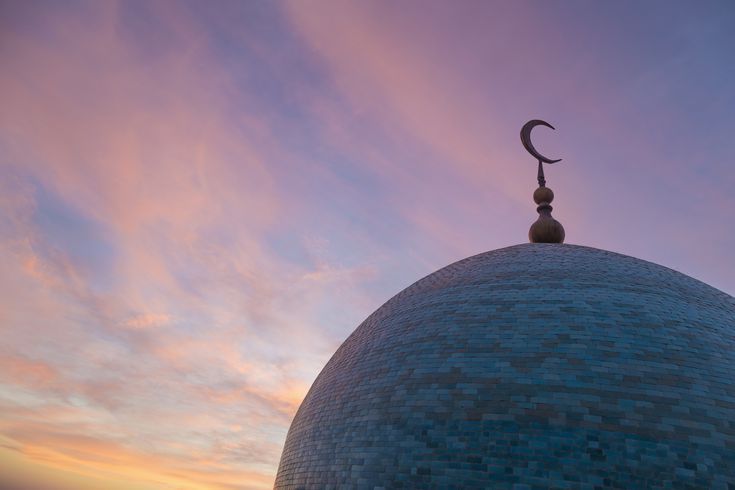 the top of a building with a crescent on it's roof at sunset or dawn