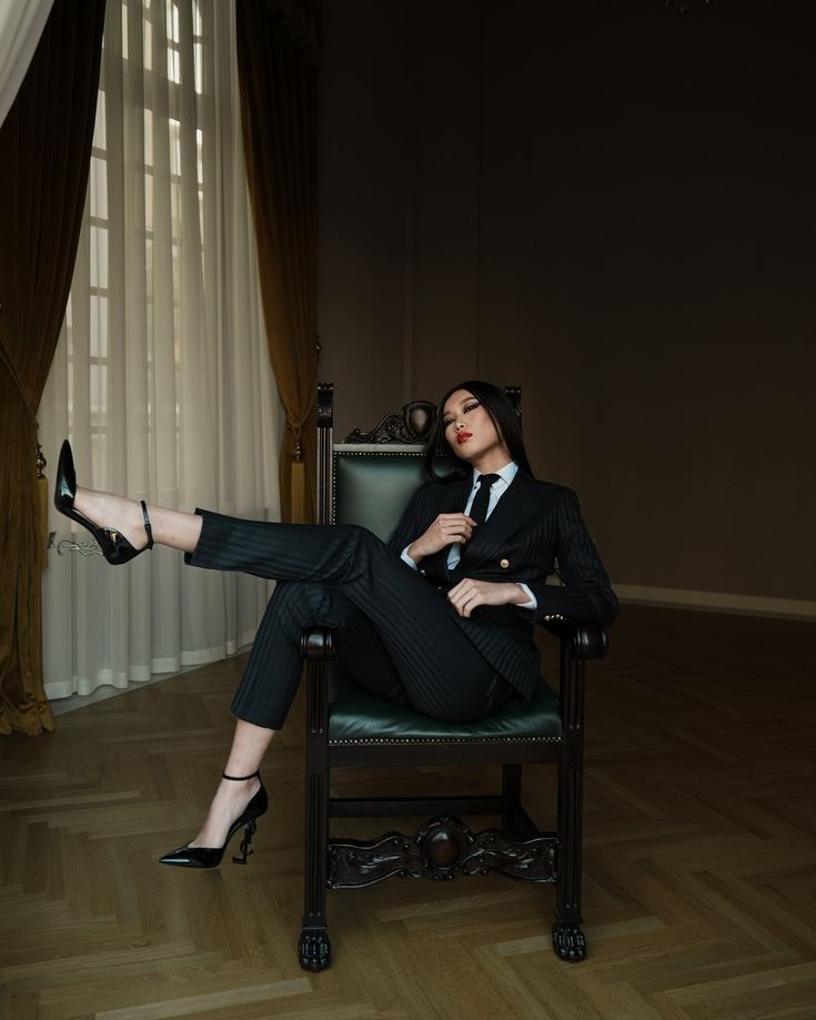 a woman is sitting in a chair with her legs crossed and wearing high heeled shoes