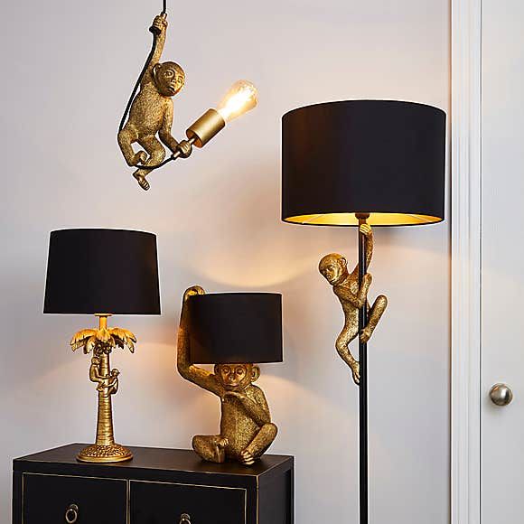 two gold monkey lamps and a black lamp