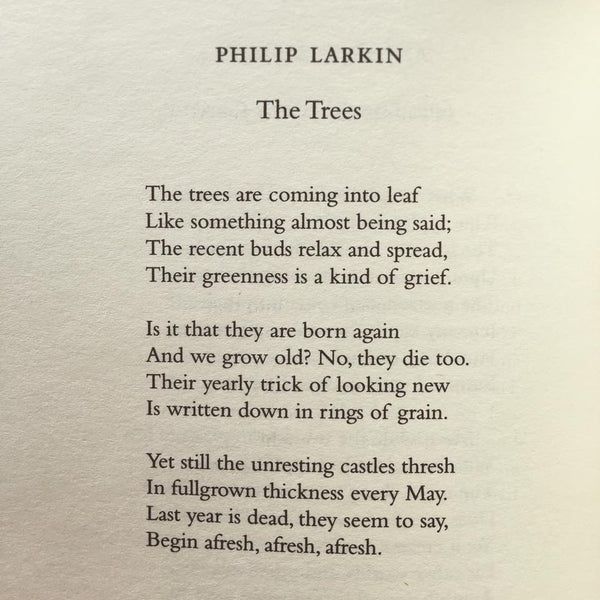an open book with the words philip larkkin and trees written in black on it