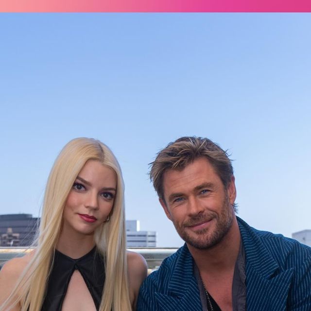 the man and woman are posing for a photo together in front of a cityscape