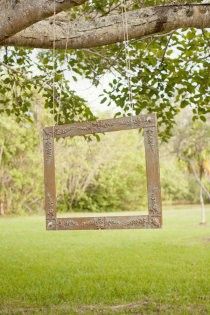 a wooden frame hanging from a tree branch