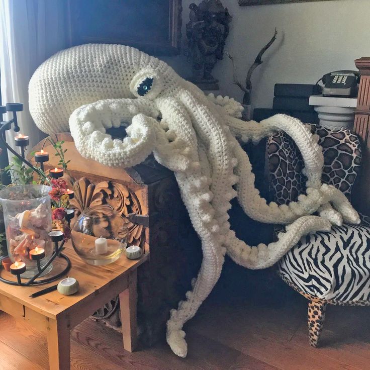 an octopus sculpture sitting on top of a wooden table next to a zebra print chair