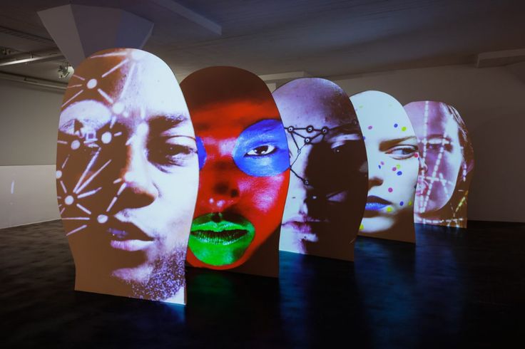 a group of skateboards with faces on them in a room filled with dark floors