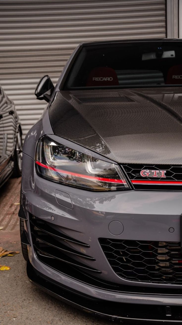 two cars parked next to each other in front of a garage