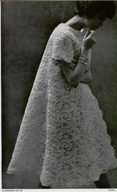 an old fashion photo of a woman in a white lace dress with her hands on her hips