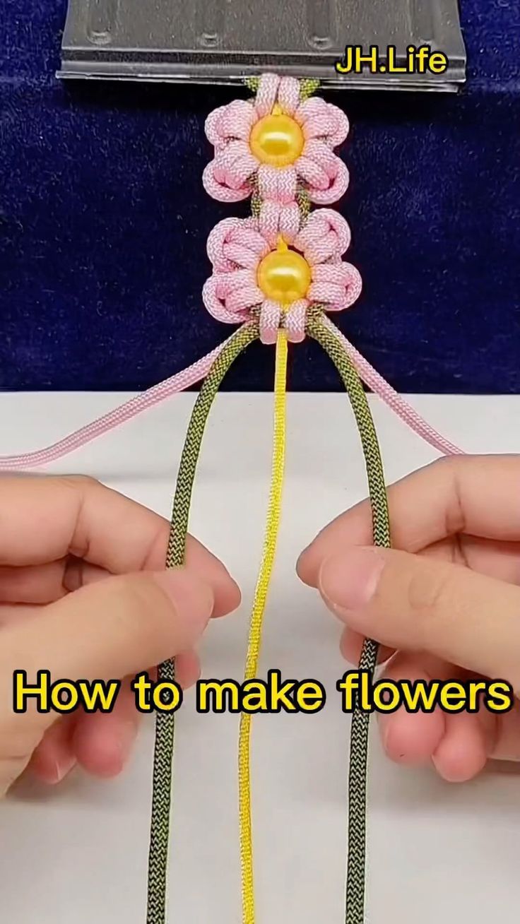 two hands are holding a piece of string with flowers on it and the words how to make flowers out of yarn