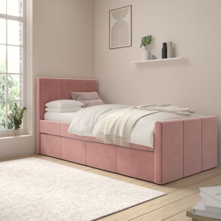 a bedroom with a pink bed frame and white linens on the floor, next to a window