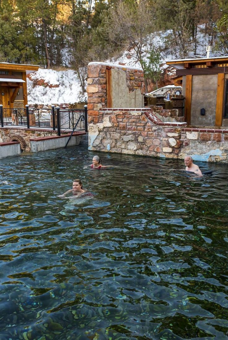 people are swimming in the water near some cabins