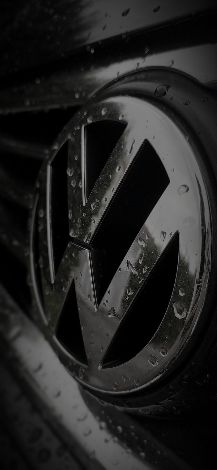 the volkswagen logo is shown in this black and white photo with water droplets on it