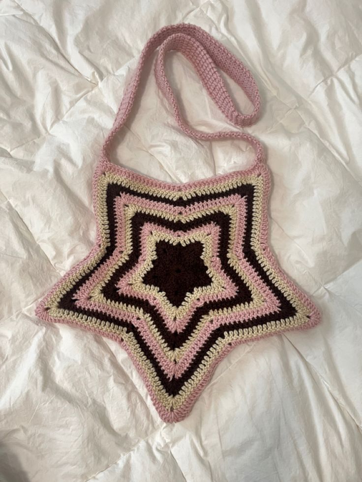 a crocheted bag sitting on top of a white sheet