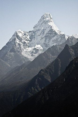 a snow covered mountain with trees in the foreground