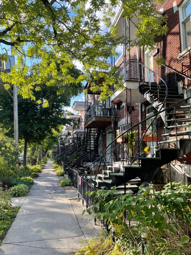 the sidewalk is lined with apartment buildings and trees