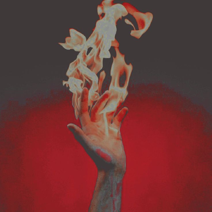 a hand holding something in the air with fire coming out of it's fingers