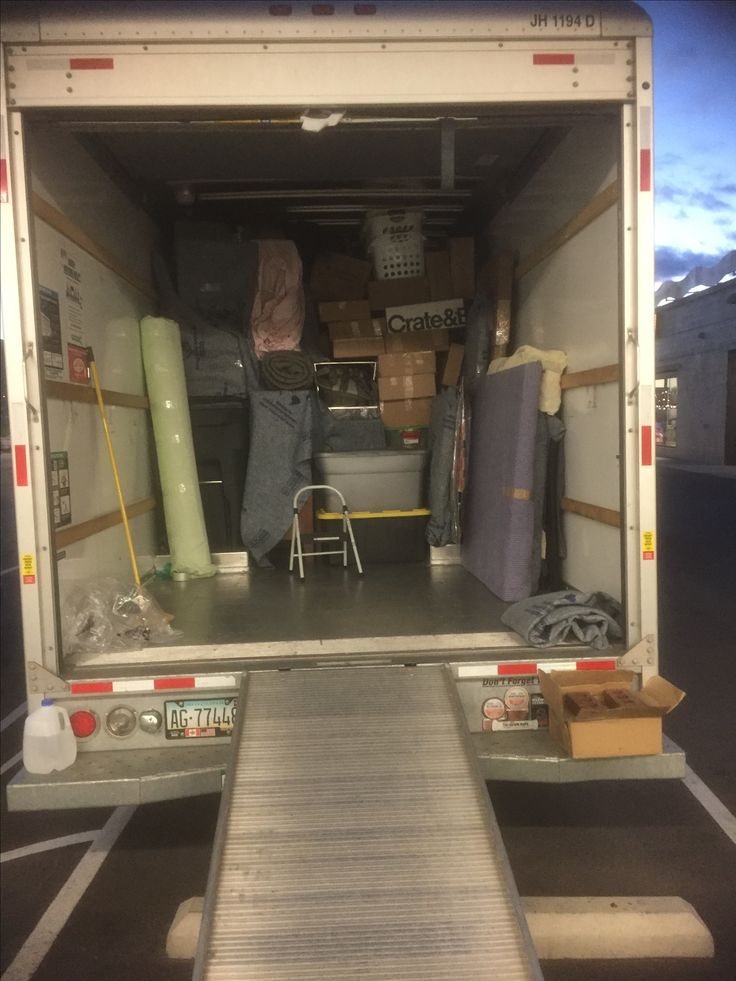 the back end of a moving truck with luggage in it's cargo area and boxes on the floor