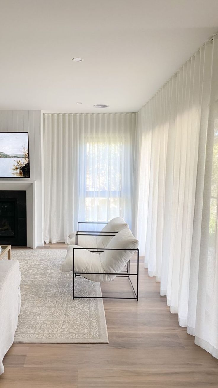 a living room filled with furniture and a flat screen tv mounted on the wall above a fireplace