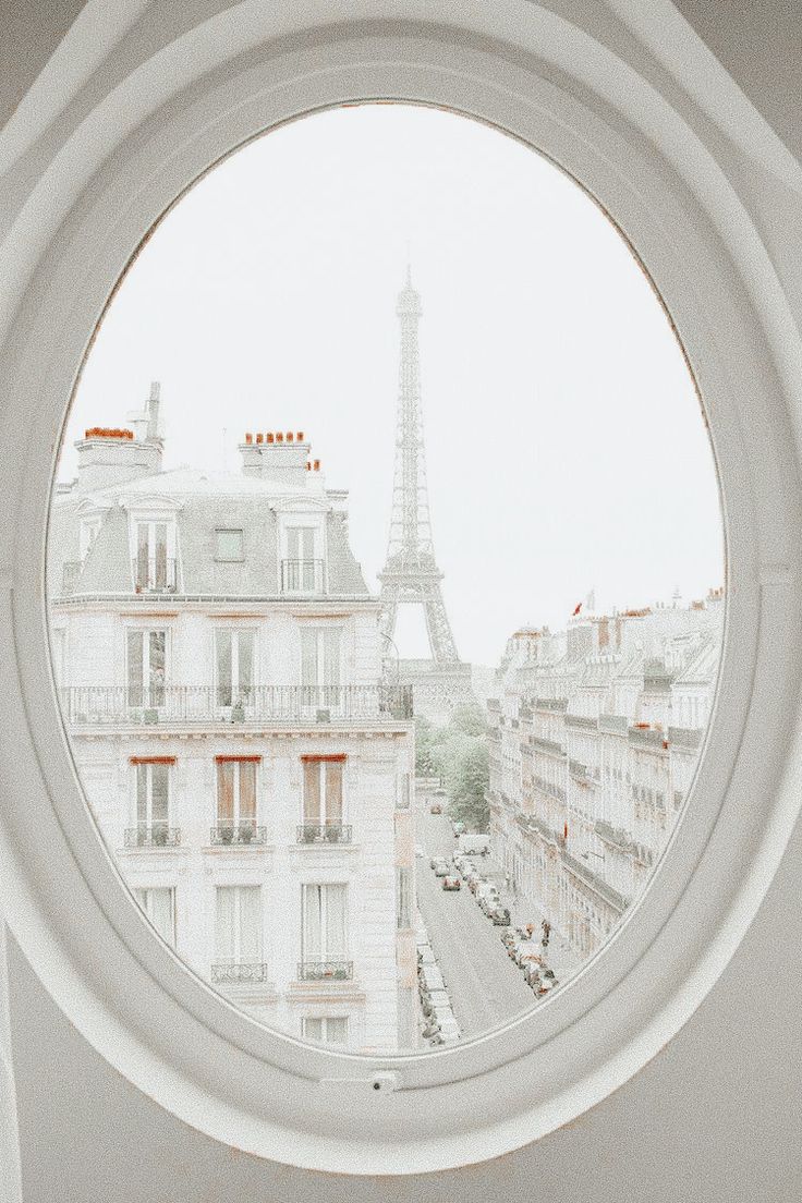 a round window with the eiffel tower in the background