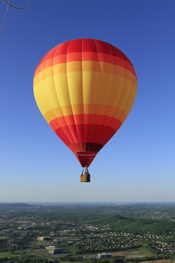 a hot air balloon flying over a city