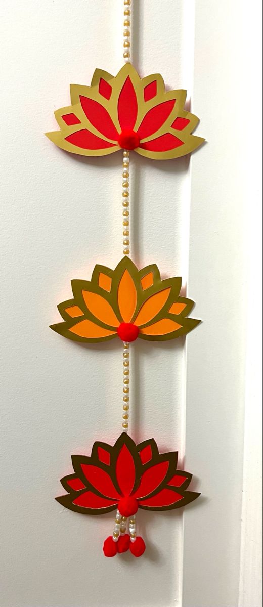 three red and yellow flowers are hanging from a door handle with beaded beads on it