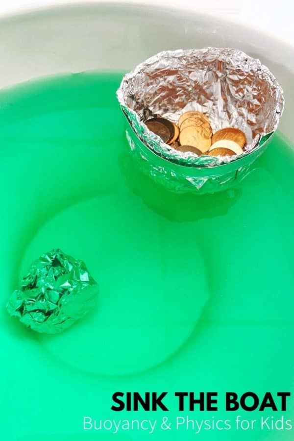 a bowl filled with green liquid next to a pile of gold and silver coins on top of it