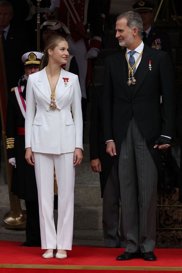 a man and woman standing next to each other in front of an official officer's uniform