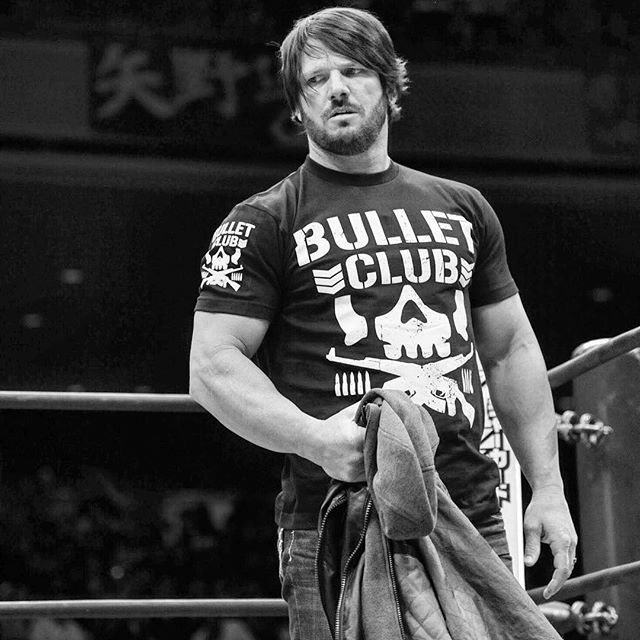 a man standing in front of a wrestling ring holding a towel and looking at the camera