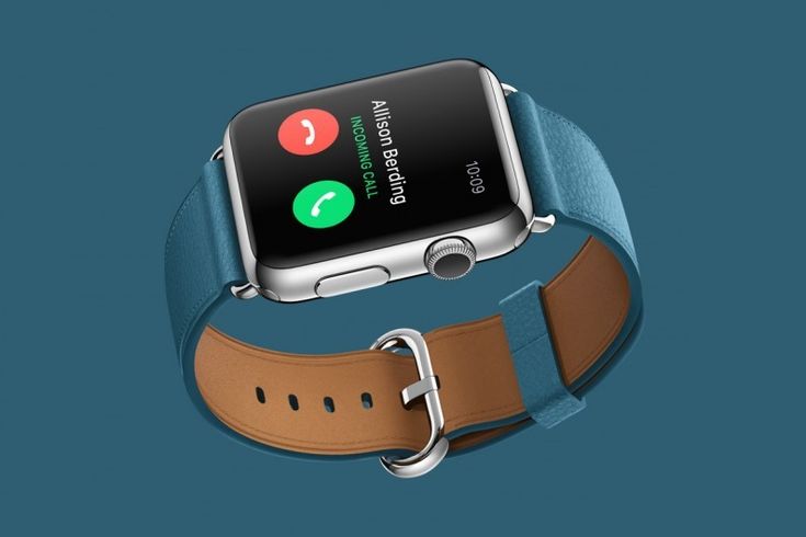 an apple watch showing the time on it's screen and its leather band, against a blue background