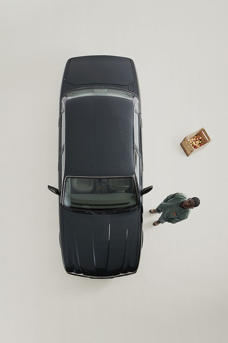 an overhead view of a car with two people standing next to it