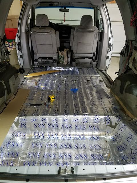 the inside of a van with plastic wrapped in blue tape and other items on the floor