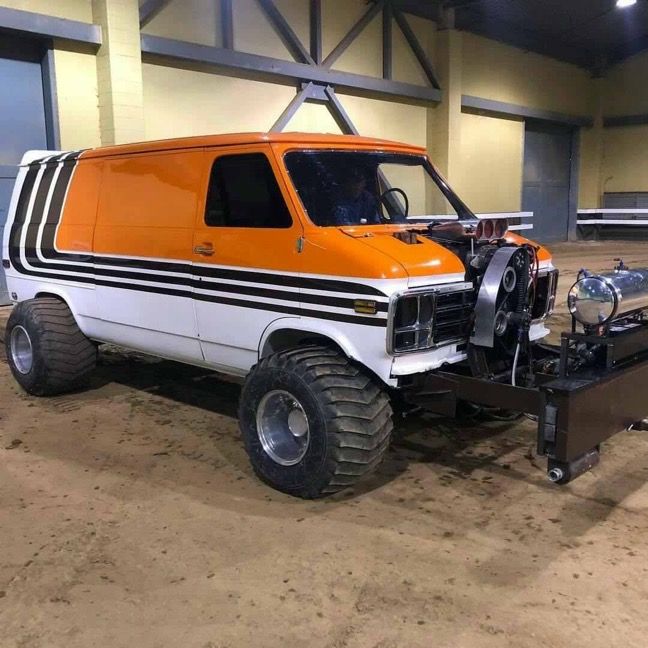 an orange and white truck is parked in a garage with a snow plow attached to it