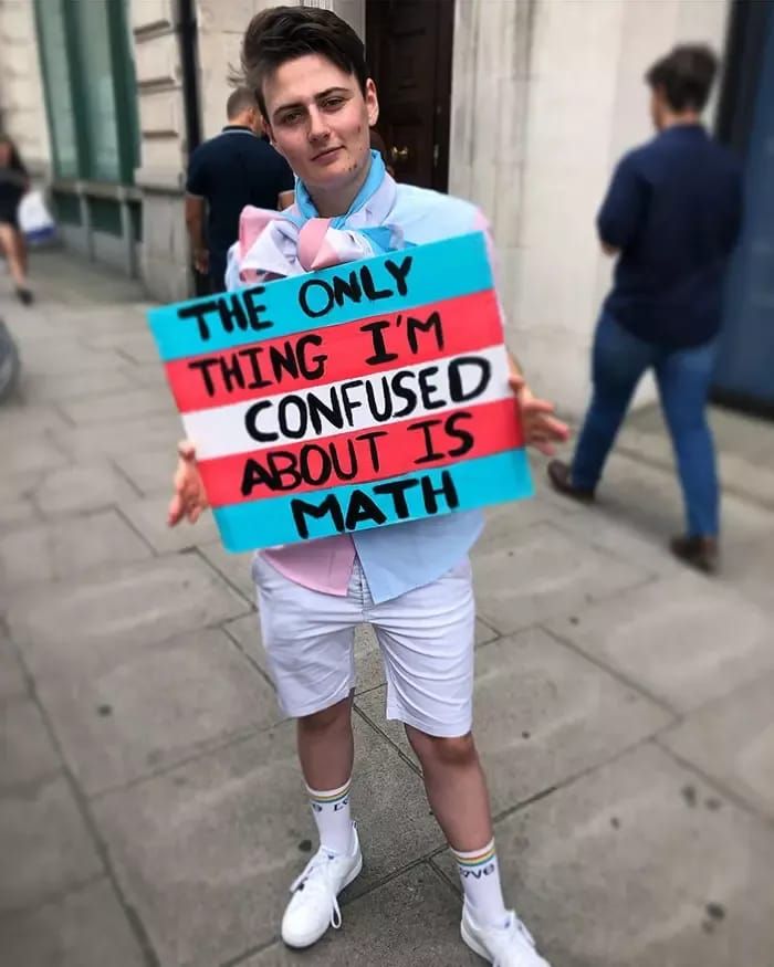 a man holding a sign that says the only thing i'm confused about is math