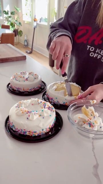 a woman is cutting into three cakes on the counter top with sprinkles