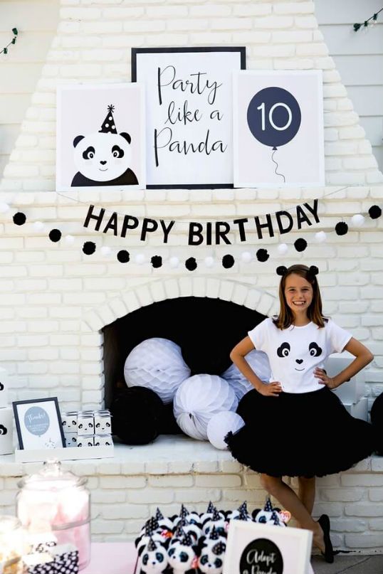 a woman standing in front of a birthday cake with pandas on it's shirt