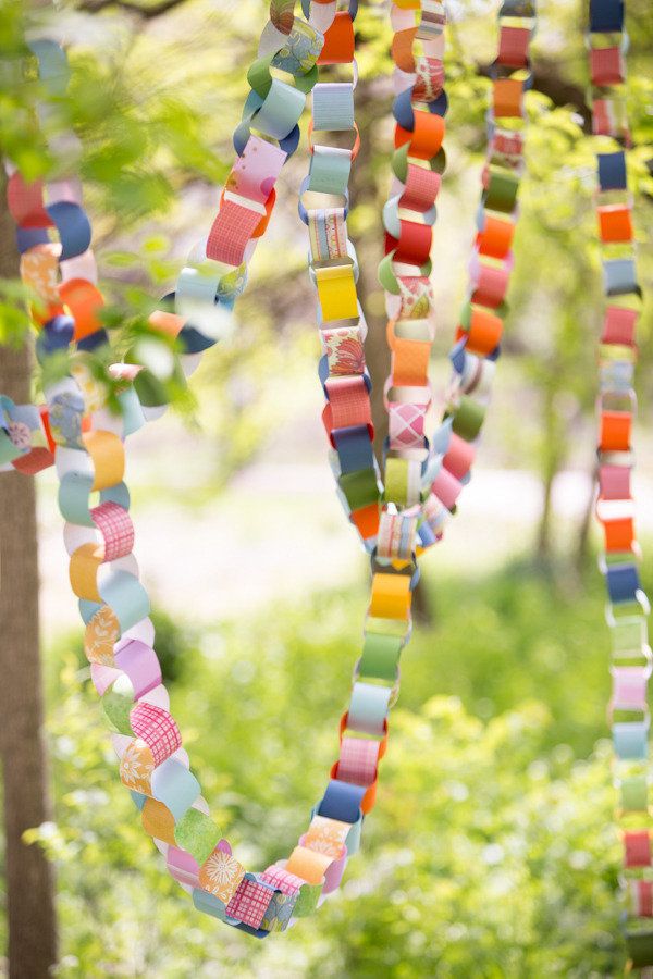 colorful paper streamers hanging from trees in the woods