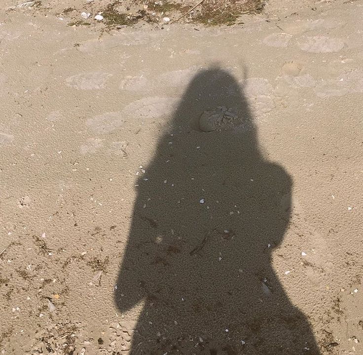 a shadow of a person on the beach