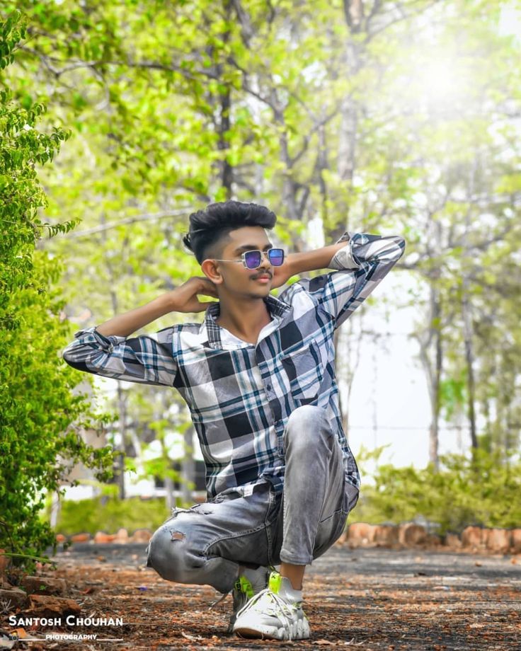 a man kneeling down in the woods with his hands behind his head