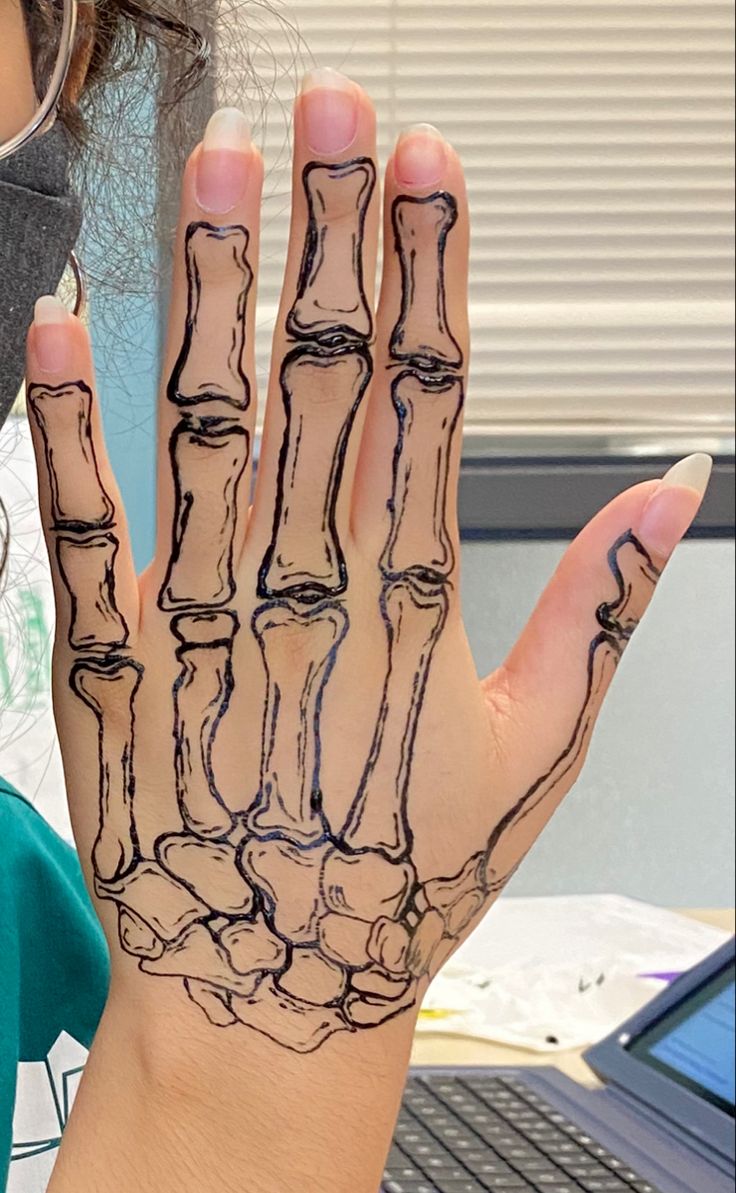 a woman with her hand painted to look like a skeleton